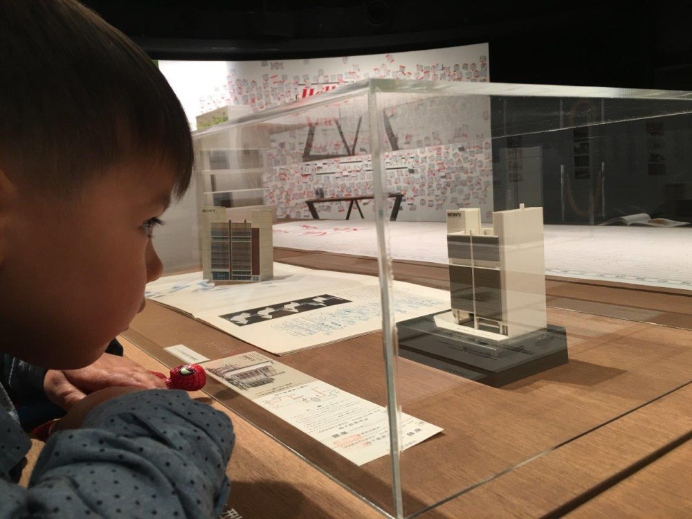 Child looking at model building
