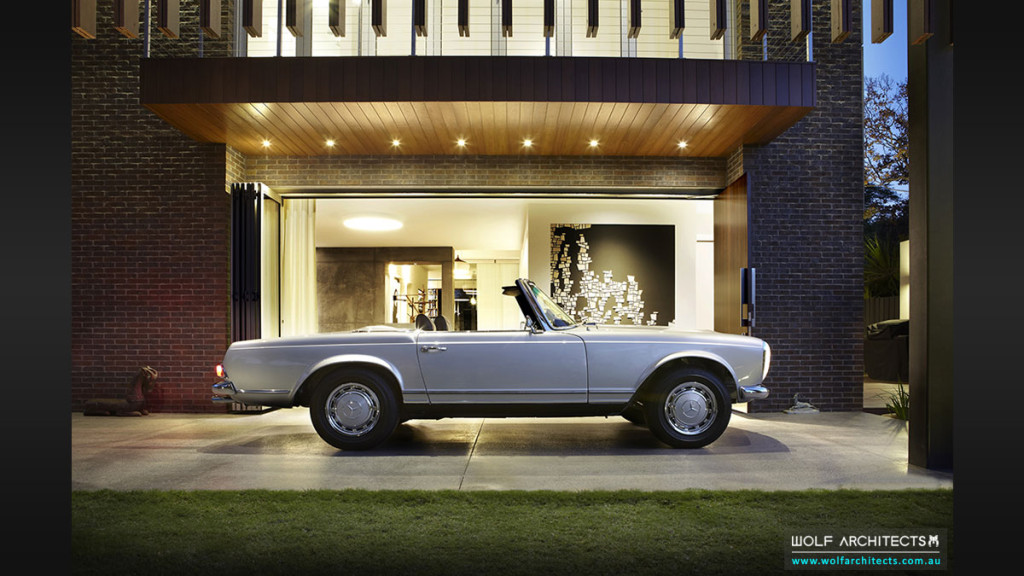 Silver Mercedes in covered entry porch of Modern contemporary house.