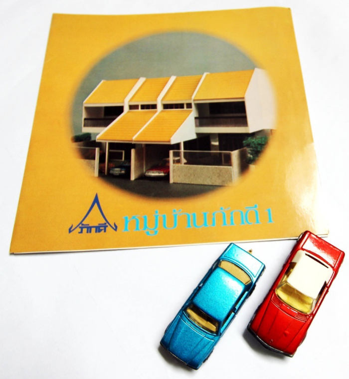 printed town house development brochure from the 70s and two matchbox cars